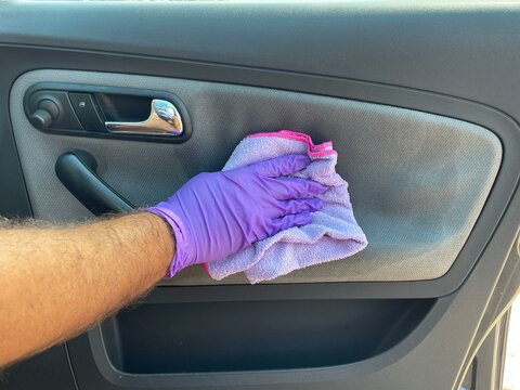 Limpiando la tapicer&iacute;a del coche con la protecci&oacute;n adecuada para las manos 