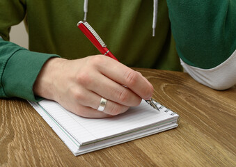 A depressed man sits at a table and writes a farewell letter.