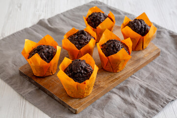 Homemade Chocolate Chip Muffins on a wooden board, side view.