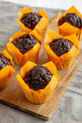 Homemade Chocolate Chip Muffins on a wooden board, side view.
