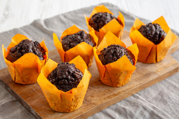 Homemade Chocolate Chip Muffins on a wooden board, side view. Close-up.