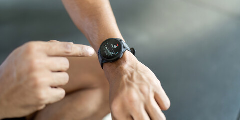 Smartwatch Usage. Man interacting with fitness watch after workout.