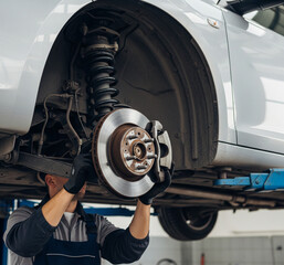 Expert Mechanic Skillfully Repairs Car on Lift, Tire in Hand
