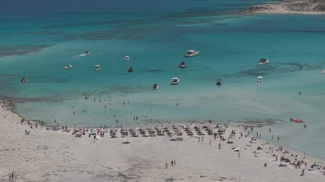 Aerial orbit view of Balos Beach and Balos Lagoon with a lot of people and boats, drone shot 4k, Crete, Greek Islands, Greece - 4K stock video 3x telephoto lense D-Log M profile