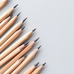 Many pencils on a light gray background, top view. Space for text