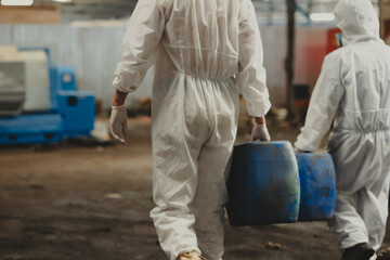 man holding Old plastic barrels containing toxic chemicals : Officials from the Department of...