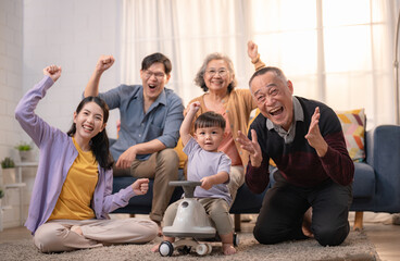 Family gathers in living room to celebrate with joy and laughter during a special moment together