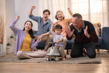 Family gathers in living room to celebrate child's achievements with joy and laughter during daytime gathering