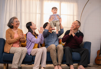 Family gathers to celebrate a joyful moment with a child at home during a bright afternoon
