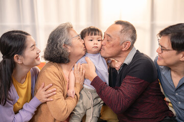 Family members sharing a joyful moment with a toddler at home during a relaxing afternoon