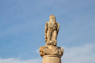 Obraz premium Ancient stone eagle statue atop a tall column at Karakuş Tumulus, Adiyaman, Turkey. This historic sculpture symbolizes strength and heritage against a serene blue sky backdrop.