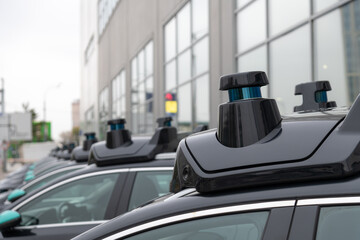 Close-up view of sensors and radar on roof of black autonomous driving vehicle (self-driving car or driverless car). Soft focus. Copy space. Futuristic transportation technology theme.