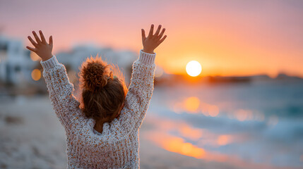 Child with curly hair joyfully raising hands towards vibrant sunset on beach, capturing the essence of happiness and freedom in nature. Selective focus