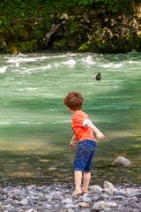 Jeux d'enfants avec des cailloux près d'une rivière en montagne