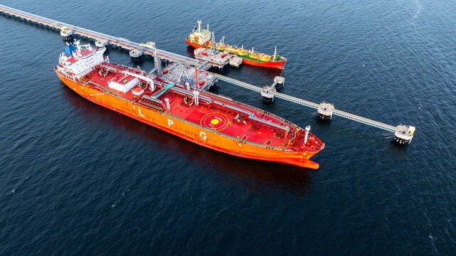 Aerial view LPG gas tanker ship at oil and gas terminal platform, Liquefied Petroleum Gas tanker ship industrial offshore oil gas terminal tanker ship LPG tanker ship loading arm loading and unloading