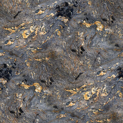 A swirled stone surface with gray, black, and gold tones, featuring intricate mineral patterns and layered texture.
