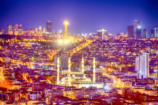 Ankara cityscape at night showcasing the iconic Atakule tower and Kocatepe Mosque beautifully illuminated, highlighting the vibrant urban life and skyline of Turkey&rsquo;s capital city.

