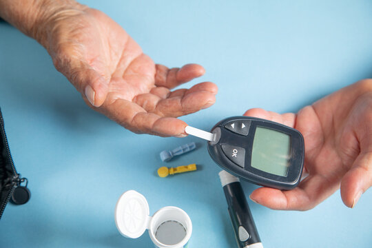 Elderly woman checking her blood sugar level.