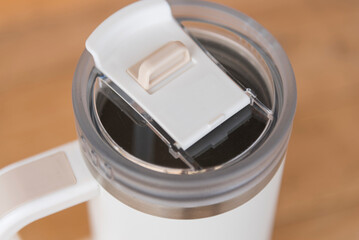 cap of White HANDLE TUMBLER on wood table 