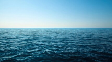 Obraz premium Calm ocean surface meeting a clear sky.