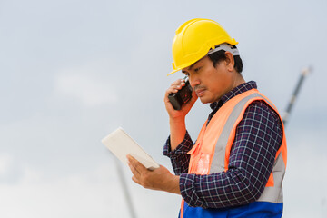 Construction Worker Communicating with Walkie-Talkie, On-Site Supervisor with Two-Way Radio and...