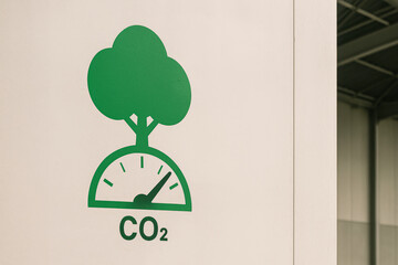 A green graphic showing a tree growing from a CO2 gauge, symbolizing carbon dioxide measurement or reduction.
