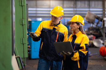 engineering team working : Caucasian mele and female manufacture technical or factory staff working with holding laptop computer standing at industry factory. Professional Mechanical Engineer