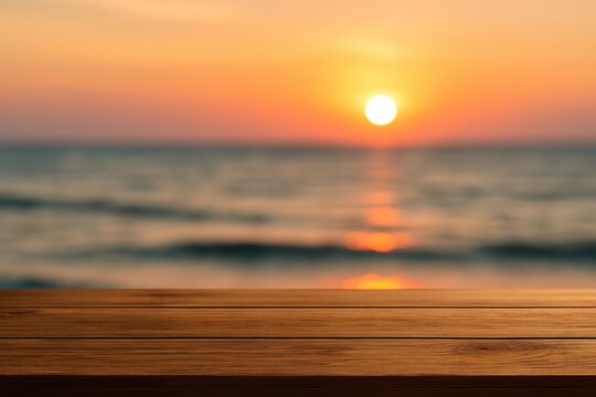 Empty wooden table with blur orange sunset background. Beautiful twilight above sea with sunny ocean view copy space.