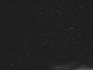 Abstract dirty dust particle grain texture for overlay effect with space for vintage grunge design. White dust on a black background. Noise black background overlay, abstract film noise, black texture