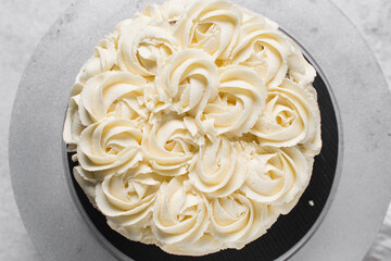overhead view of Buttercream rosette cake on a cake stand, Cake covered in buttercream rosettes, process of decorating a cake with roses