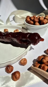 Nuts and dried fruits in pomegranate juice on a plate. Churchkhela. Georgian churchkhela in pomegranate juice