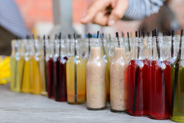 Assorted Bottled Beverages with Straws on Rustic Wooden Table