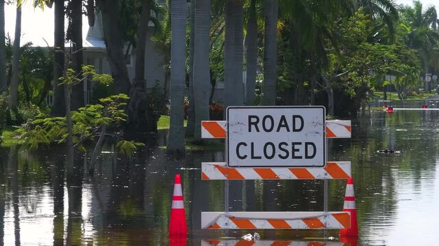 Hurricane Milton aftermath in Punta Gorda, Florida. City street closed because of flooding with warning signs blocking driving of cars.