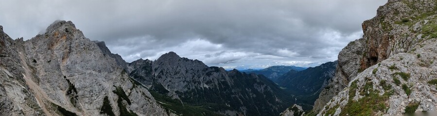 Panoramic view of Logarska dolina valley with peaks of Slovenian Alps covered by passing clouds.