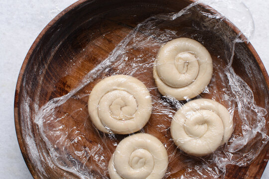 Overhead view of rolled paratha dough, top view of flaky flatbread dough, process of making paratha	