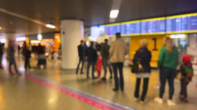People waiting to greet passengers stand at arrival gate 1 at Warsaw Chopin Airport (WAW), Poland. Out of focus.