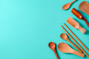 Wooden spoon, chopsticks and equipment on a color background. Top view.