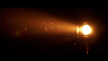 A bright spotlight shines in the dark illuminating dust motes in its beam - Powered by Adobe