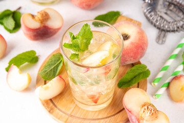 Flat peach lemonade, iced tea or mojito cocktail with fresh fruit garnish. Sweet non-alcohol flat chinese donuts fig peach mocktail with peach slices, mint and crushes ice