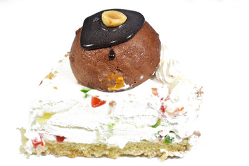 a triangular piece of Cassata ice cream cake, vanilla, whipped cream, milk, filled with dried fruit, topped with chocolate ball and sauce with a hazelnut on a base of sponge baked cake
