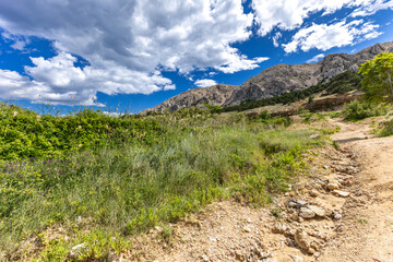 Hiking trail leading from the beach in Baska to the Bag mountain, city panorama seen from above,
