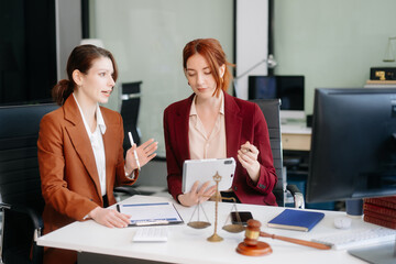 Professional female lawyers consulting on legal cases in a modern office. Perfect for law, business, justice
