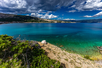 Hiking trail leading from the beach in Baska to the Bag mountain, city panorama seen from above,