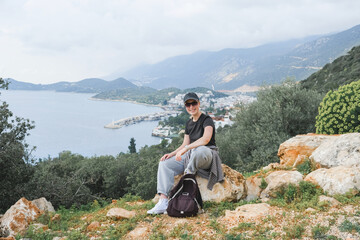 Solo female traveler enjoys scenic coastal view during eco-conscious hiking retreat. Digital nomad...