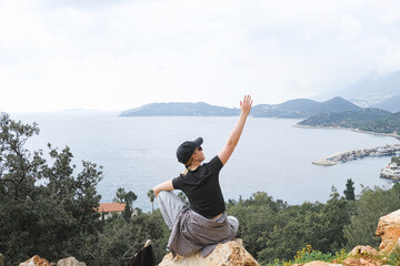 Solo female traveler enjoys scenic coastal view during eco-conscious hiking retreat. Digital nomad...