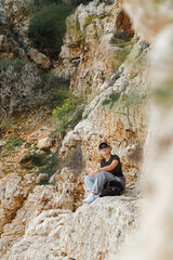 Solo female traveler enjoys scenic coastal view during eco-conscious hiking retreat. Digital nomad lifestyle, nature detox, and mindful escape for remote work and inner balance.