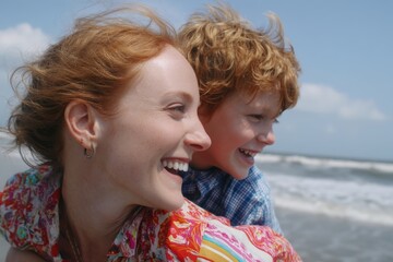 Happy redhead mother giving son piggyback ride at beach