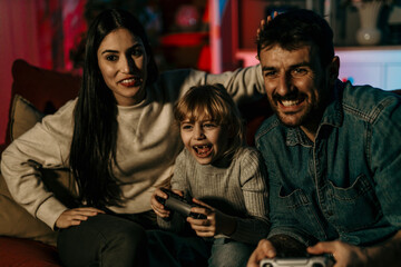 Family enjoying video games on sofa in living room