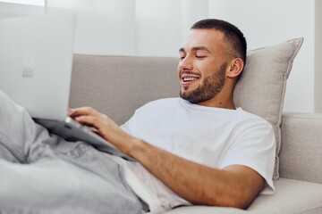 Relaxed man enjoying remote work on a laptop, showcasing emotional well-being and the balance...
