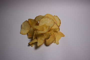 Crispy golden potato chips on white background, top view snack food concept